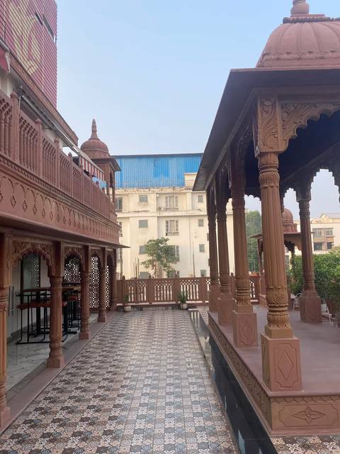 Ornate wooden verandah with carved pillars overlooking city buildings