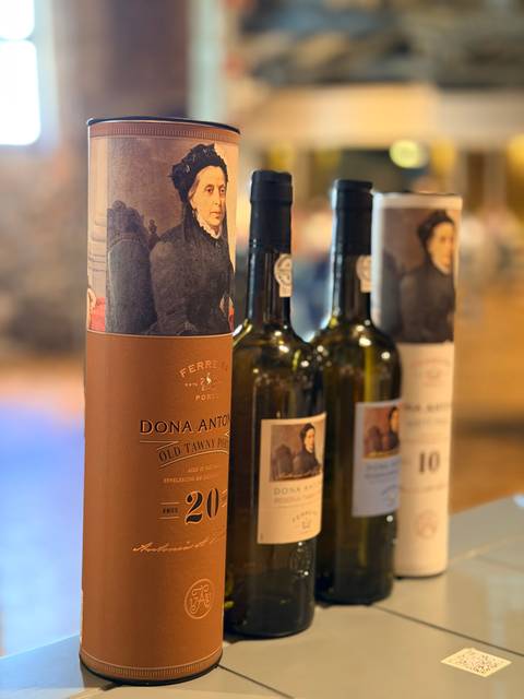 Close-up of bottles of Portuguese port wine displayed in a cellar.