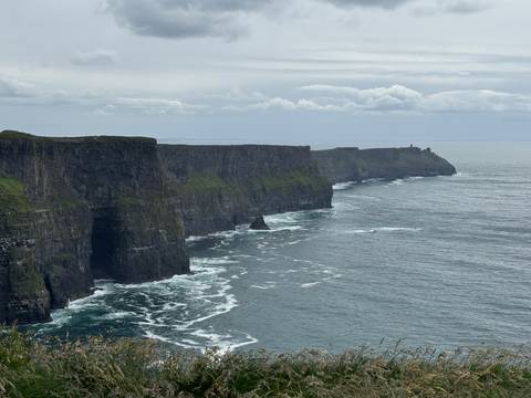Iconic cliffs rising vertically from the Atlantic Ocean with waves below