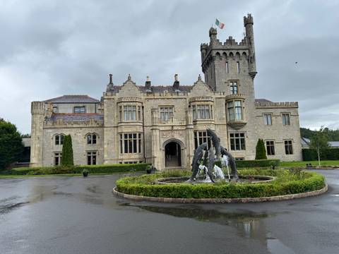 Grand stone castle hotel with central fountain on a rainy day
