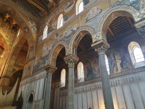Ornate Byzantine-style mosaics and arches inside Monreale Cathedral, Sicily.