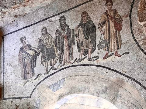 Ancient Roman floor mosaic depicting a procession of figures.
