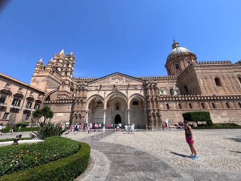 Wide view of Palermo Cathedral’s ornate exterior with tourists in the forecourt.