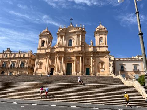 Baroque Cathedral of Noto with broad staircase leading up to ornate twin towers.