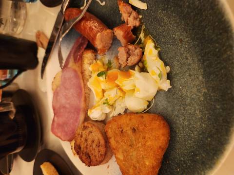Close-up of a hearty Irish breakfast with eggs, bacon, sausage, and hash brown.