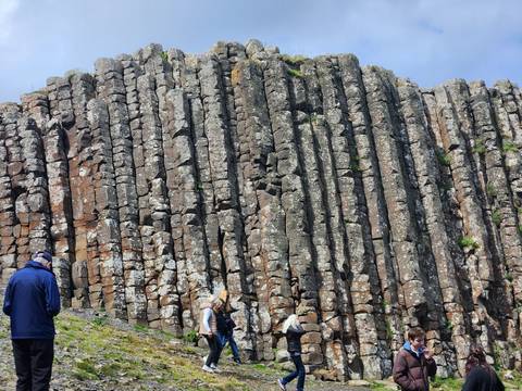 Tourists examining the towering hexagonal basalt columns of the Giant’s Causeway.