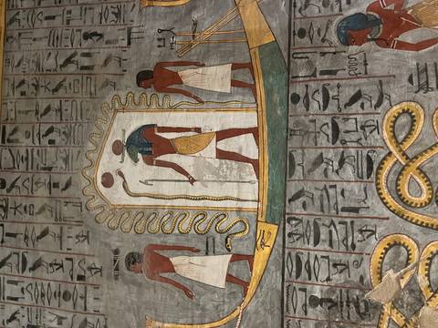 Detailed vertical mural of Egyptian deities with hieroglyphics on a tomb wall.
