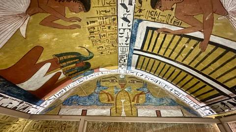 Vividly painted pharaonic ceiling with ancient Egyptian gods and hieroglyphs.