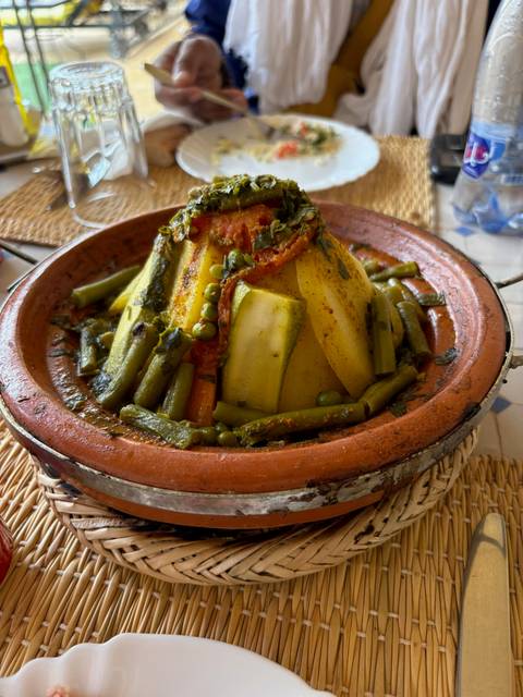 Vegetable tagine served in a traditional clay pot with rich spices and sauce.