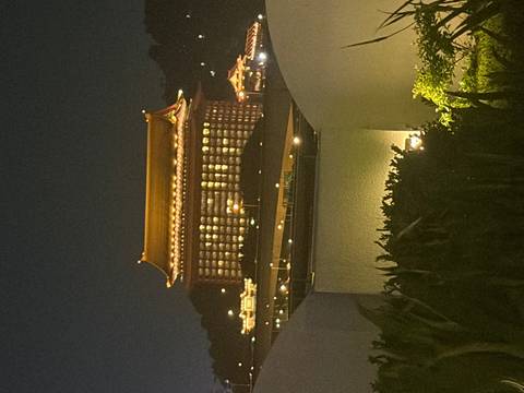 A large traditional Chinese-style hotel dramatically illuminated at night.