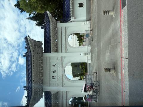 The white-arched Liberty Square gate with blue tiles stands beneath a partly cloudy sky.