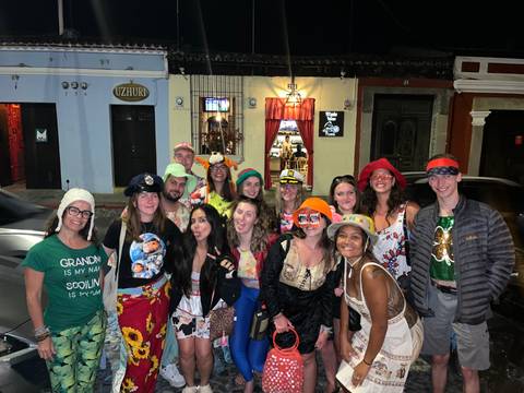 Colorfully dressed travelers posing at night street party in Latin town