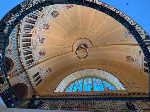 Decorative domed ceiling with ornate patterns and a colourful stained-glass window.