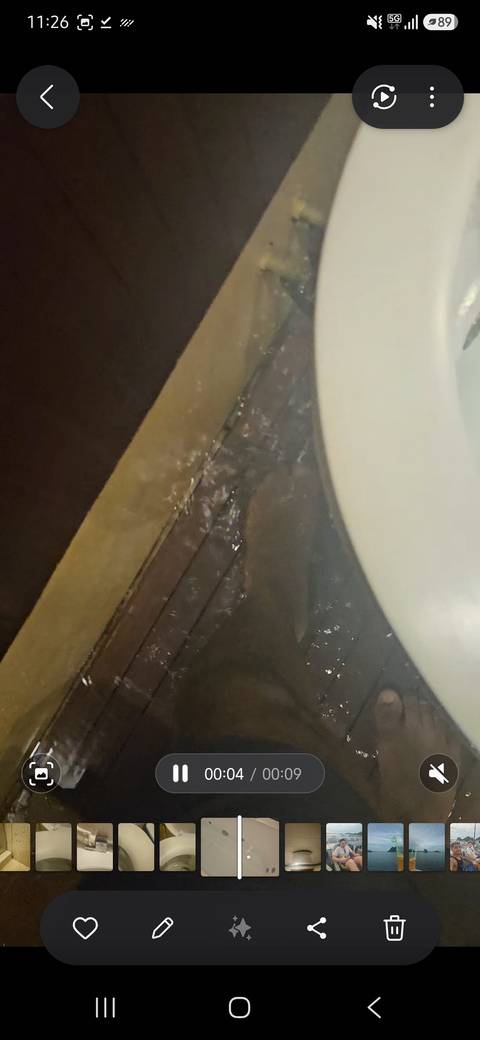 Out-of-focus shot of water on a bathroom floor and toilet base.