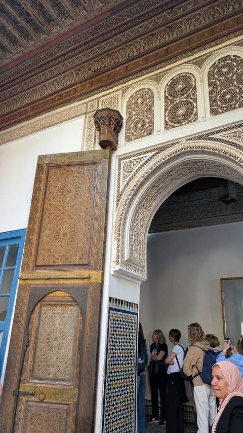 Close-up of carved wooden door and ornate stucco arch in Marrakesh palace