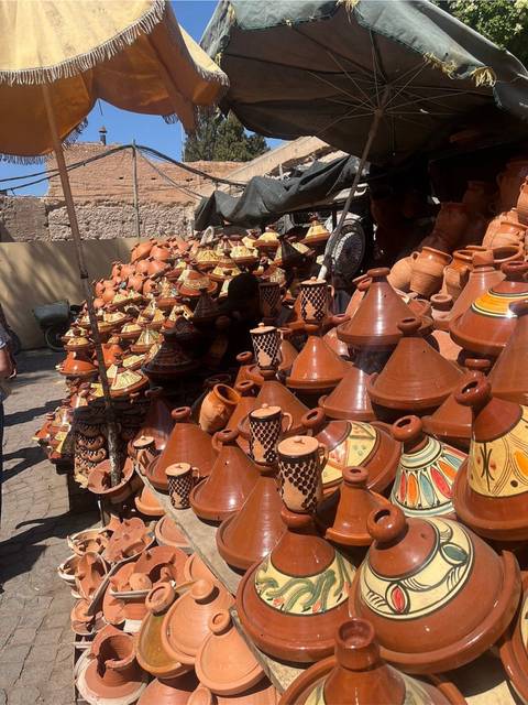 Street market stall stacked with rows of clay tagine pots