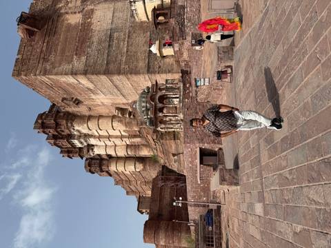 Traveller poses in front of towering Mehrangarh Fort walls and bastions in Jodhpur.