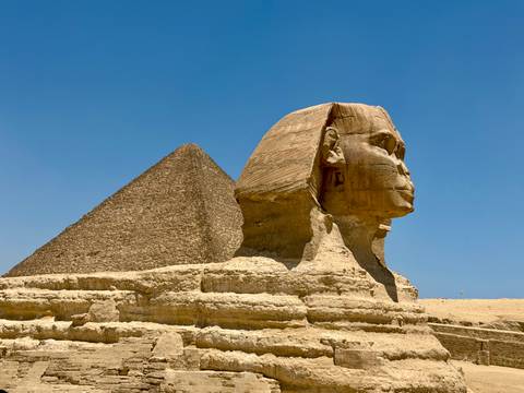 Iconic Great Sphinx with Khafre pyramid behind under a clear blue Egyptian sky