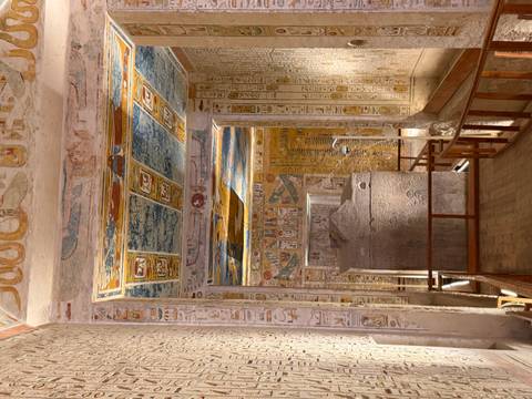 Richly painted interior corridors of an ancient pharaoh's tomb with hieroglyphics and sarcophagus