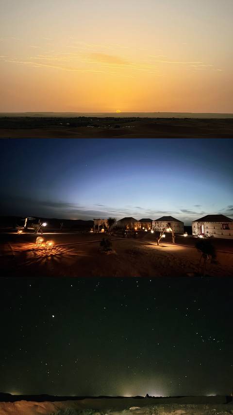 Remote desert camp at twilight with canvas tents softly lit by lanterns.