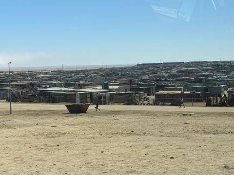 Expansive view of a dusty shanty settlement on barren desert outskirts