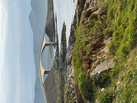 Curving concrete bridge of the Atlantic Ocean Road spans rocky islets amid calm coastal waters