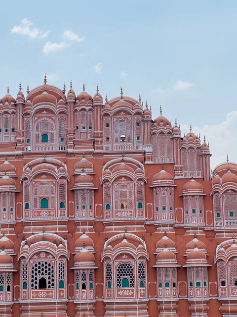 The pink sandstone honeycomb facade of Jaipur's Hawa Mahal fills the frame