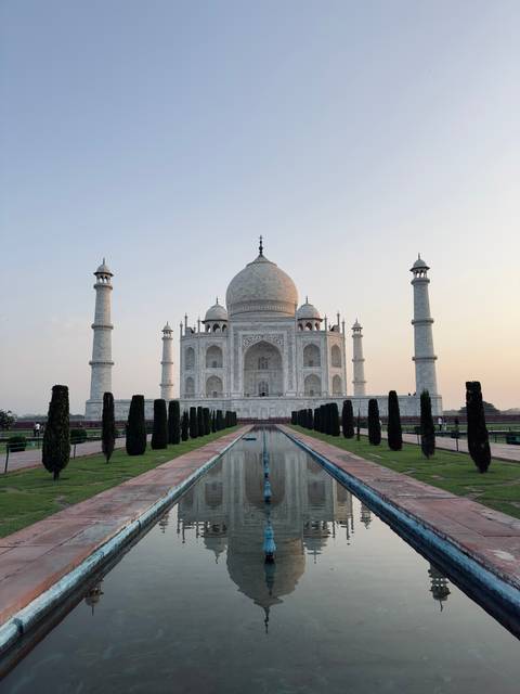 Classic frontal view of the Taj Mahal reflected in the long water channel at dawn