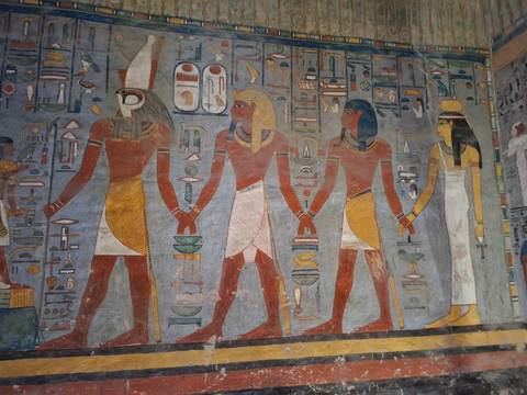 Colorful, detailed wall reliefs of ancient Egyptian deities inside a tomb.