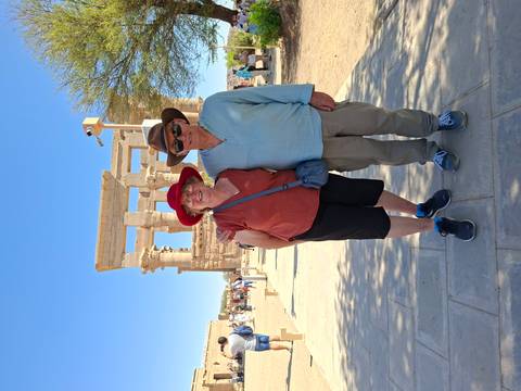 Travelling couple posing in front of ancient stone columns at Philae Temple.