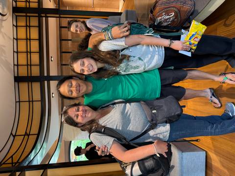 A friendly farewell photo of travellers with a local guide inside a reception area.