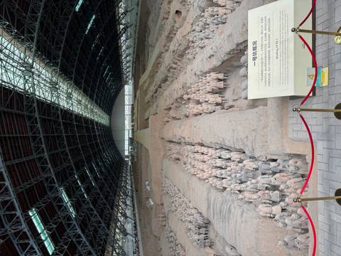 Wide interior of Pit 1 displaying rows of the Terracotta Warriors beneath a vast steel roof.