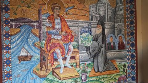 Colorful mosaic artwork depicting historical figures and architecture displayed indoors.