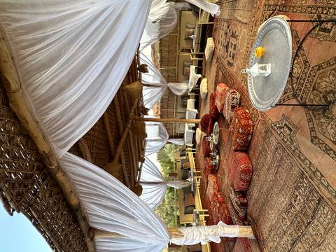 Cozy Moroccan lounge under draped white fabric with patterned cushions and low tables