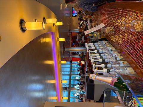 Well-stocked bar on a cruise ship with bottles, snacks and warm ambient lighting
