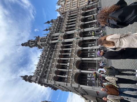 The elaborate neo-Gothic façade of Brussels’ Town Hall towering over visitors in the cobblestone square.