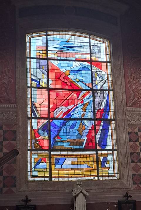 Close-up of a colourful abstract stained-glass window inside a historic building