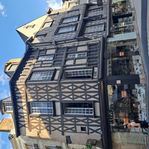 Historic timber-framed building with shoe shop and sale signs on a city street