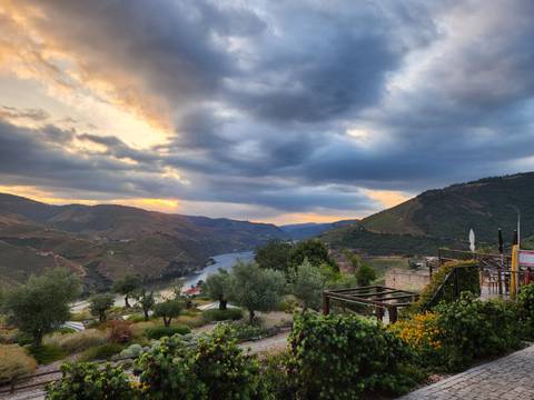 Dramatic sunset clouds over the winding Douro River and terraced vineyards
