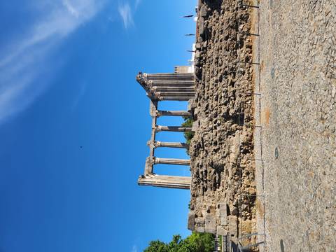 Ancient Roman Temple of Diana with tall columns against a vivid blue sky in Évora