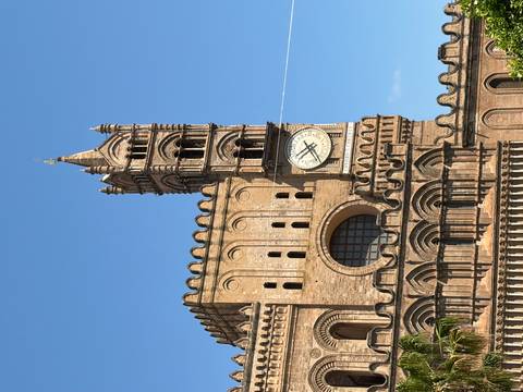 Detailed view of Palermo Cathedral’s clock tower against a clear blue sky