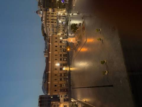 Nighttime view of an illuminated historic square in Palermo with a central monument