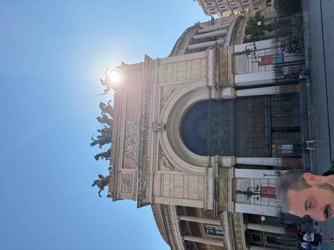 Front arch of Teatro Politeama Garibaldi with sun flare and bronze quadriga sculpture