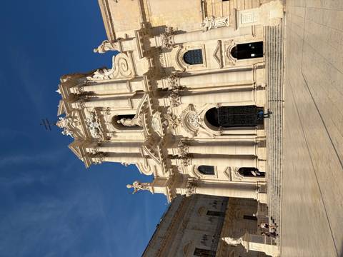 Grand Baroque Cathedral of Syracuse gleaming under clear blue Sicilian sky