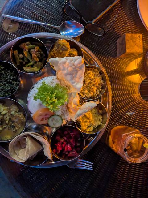 Traditional Sri Lankan rice and curry meal arranged on a round metal platter