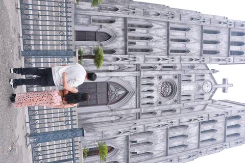 Couple standing arm-in-arm facing the gothic façade of St. Joseph’s Cathedral in Hanoi.