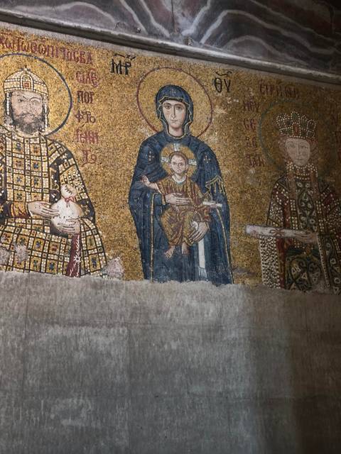 Detailed gold and blue Byzantine mosaic depicting religious figures on an interior wall.