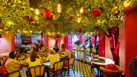 Vibrant interior of a Vietnamese restaurant with hanging lanterns and groups enjoying meals.