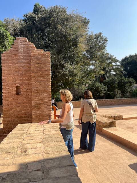 Two women exploring ancient brick ruins in warm afternoon light.