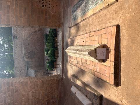 Single stone grave marker inside historic site with afternoon light.